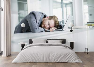 Tired young man in the office Wall mural