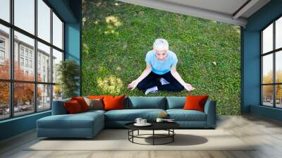 Top view at senior woman does lotus pose for relaxation Wall mural