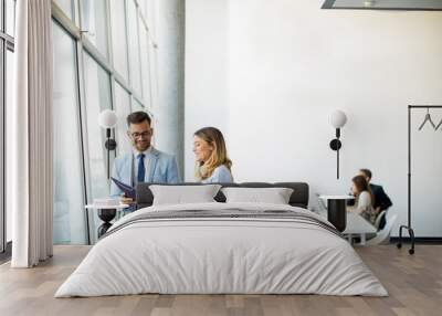 Two business people looking a file in a modern office Wall mural