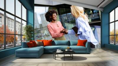 Two Professional Women Sharing a Joyful Conversation at a Modern Office Building. Generative AI Wall mural