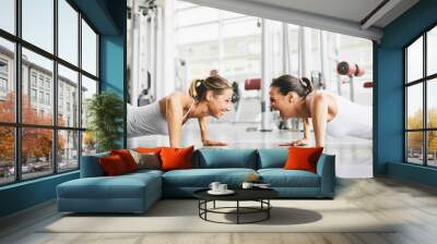 two smiling young women exercising in a gym Wall mural