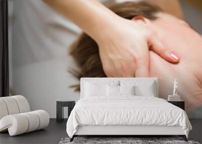 Woman getting a stress relieving pressure point massage on her neck by a health therapist Wall mural