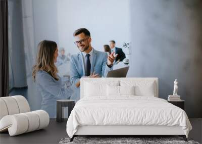 Young business couple working and discussing by laptop in the office Wall mural