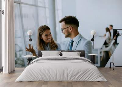 Young business couple working and discussing by laptop in the office Wall mural