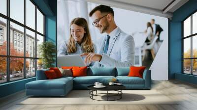 Young business couple working and discussing by laptop in the office Wall mural