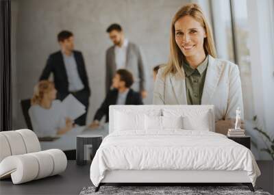 Young business woman standing in the office in front of her team Wall mural