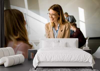 Young business women giving friendly handshake in the office Wall mural