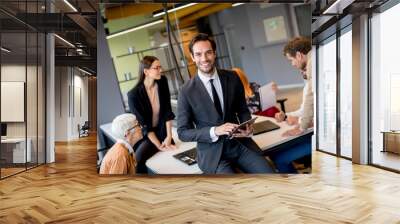 Young businessman using digital tablet in office Wall mural