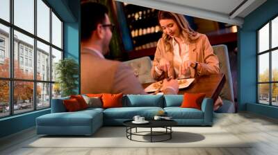 Young couple having a dinner in the restaurant and drinking red wine Wall mural