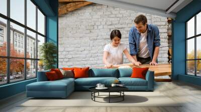 Young father and his cute daughter making dough at home kitchen Wall mural