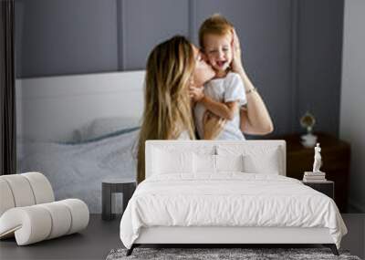 Young mother with son in the bed Wall mural