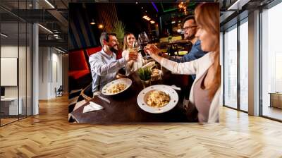 Young people having dinner in the restaurant Wall mural