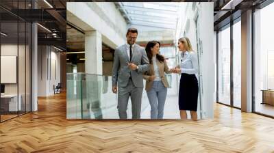 Young startup team have a discussion while walking in the modern office corridor Wall mural