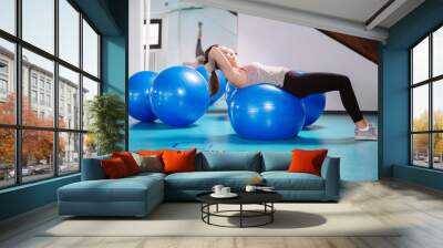 Young woman exercise with pilates balls Wall mural