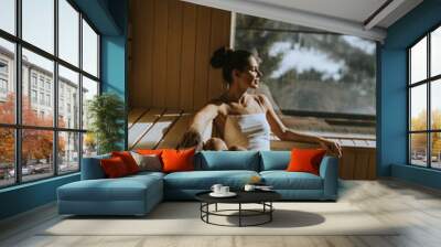 Young woman relaxing in the sauna Wall mural