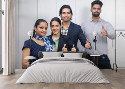 Portrait of confident Indian businesspeople raising their thumb as sign of victory, business deal, group of young entrepreneurs. Wall mural