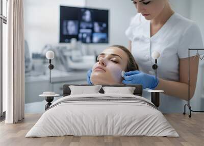 Aesthetician performing a microdermabrasion treatment in a beauty clinic focused on skin rejuvenation modern equipment and expertise Wall mural