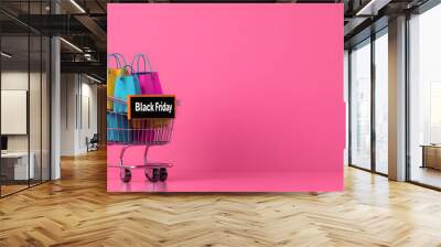 Black Friday Shopping Cart With Colorful Bags on Pink Background Wall mural