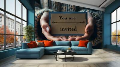 Hands holding an invitation card to an event written You are invited, invitation concept Wall mural