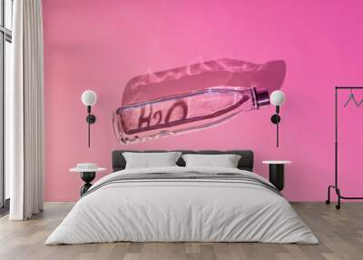 Transparent bottle of water against pastel pink background. Summer concept, refreshment, recharge. Wall mural