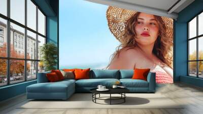 Young beautiful girl, plus size model with straw hat on the beach, summer holidays, vacation and fun Wall mural