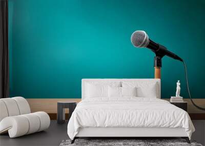 A wooden podium with a microphone in front of a teal background. Wall mural