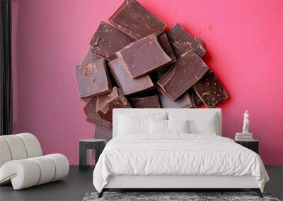 Closeup of dark chocolate pieces on a pink background. Wall mural