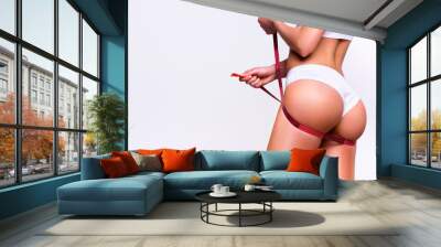 Woman measures her buttocks, losing weight Wall mural