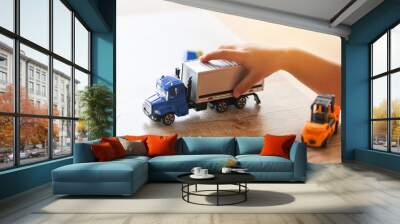 child boy playing toys on table at home - kid hands playing toy car truck Wall mural