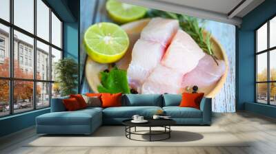 Fish fillet on wooden plate with ingredients celery for cookin, fresh raw pangasius fish fillet with lemon lime, meat dolly fish tilapia striped catfish Wall mural