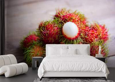 Fresh and ripe rambutan sweet tropical fruit peeled rambutan with leaves, Rambutan fruit on wooden background harvest from the garden Wall mural