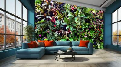 Plant wall with lush green colors, variety plant forest garden on walls orchids various fern leaves jungle palm and flower decorate in the garden rainforest background Wall mural