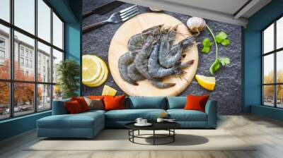 raw shrimps on wooden cutting board plate - fresh shrimp prawns for cooking with spices lemon on dark background in the seafood restaurant Wall mural