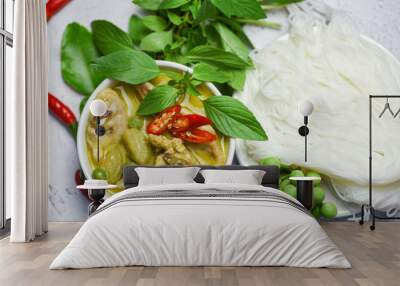 Thai food green curry chicken on soup bowl and thai rice noodles vermicelli with ingredient herb vegetable - asian food on the table Wall mural