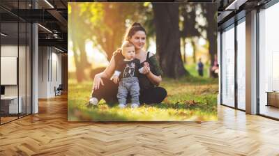 Mother and little child outdoors in park on sunny fall day. Mom and baby outside in autumn. Matte filter, natural lighting. Wall mural