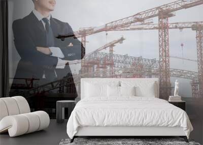 Double exposure businessman looking at construction work and crane building commercial site Wall mural