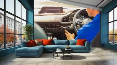 Man starts the car engine with start-stop button. Wall mural