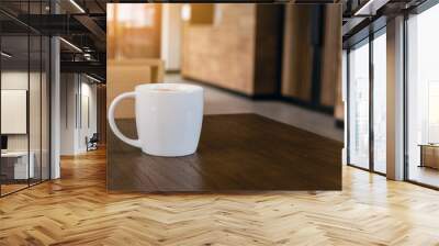 white coffee cup with hot cappuccino coffee on wooden table in coffee cafe. copy space for adding te Wall mural