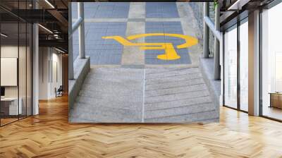 Yellow painted handicapped sign traffic symbol on the floor in front of ramp way for support wheelchair Wall mural