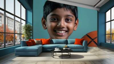 portrait of smiling indian boy holding basketball studio lighting shallow depth of field Wall mural