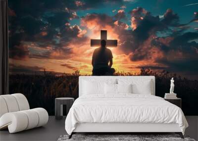 silhouette of man kneeling in worship before illuminated cross in dramatic cloudy sky spiritual faith concept Wall mural