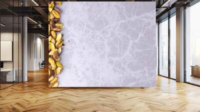 Background useable separated pistachios standing on the edge of the marble counter Wall mural