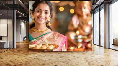 Young beautiful indian woman in saree, holding laddoo plate on diwali festival Wall mural