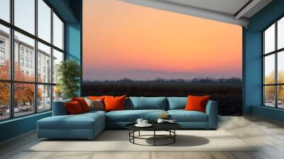 Beautiful evening panoramic landscape with bright setting sun over distant mountain peaks at sunset Wall mural