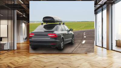 Car with roof luggage box container for travel on a road Wall mural