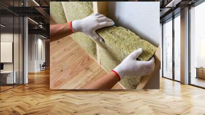 close-up of worker hands in white gloves insulating rock wool insulation staff in wooden frame for f Wall mural