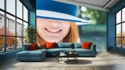 Portrait of gorgeous smiling teenage girl in yellow hat and with red hair outdoors on sunny summer day. Wall mural