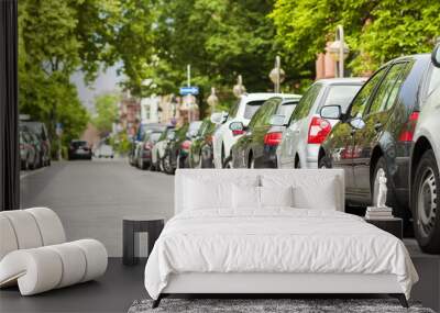 Rows of cars parked on the roadside in residential district Wall mural