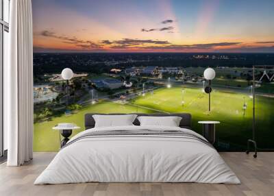 Sportsmen training in soccer game on illuminated football stadium in public sports park in North Port, Florida Wall mural