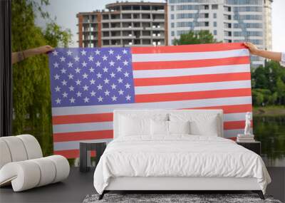 Two human hands holding USA national flag. Celebration of United States independence day concept. Wall mural